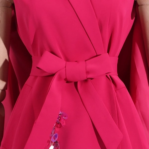 Detail of rose pink suit jacket with bow tie waist and purple gradient sequins