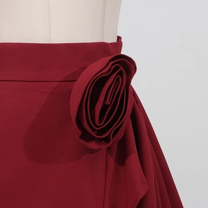 Détail d'une jupe longue bordeaux élégante avec fleur 3D décorative sur la taille haute