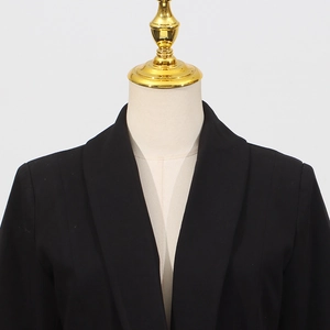 Close-up of sleek black blazer neckline with tailored shoulder design on a mannequin