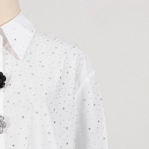 Close-up of white dress shirt with rhinestone collar and 3D floral accents on front