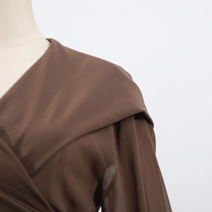 Detail of dark brown V-neck shirt featuring elegant shawl design and sheer chiffon sleeves
