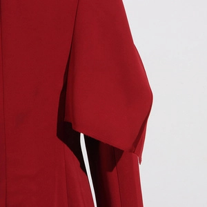 Détail rapproché de la manche à volants élégants sur un trench-coat rouge chic
