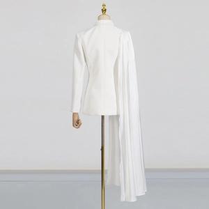 Detail of white slim blazer featuring a long silk scarf drape on the shoulder