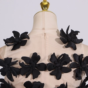 Close-up of black 3D floral appliques and invisible zipper on mesh fabric top