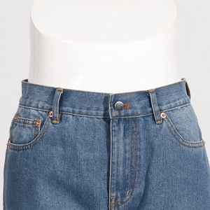 Close-up of classic blue denim jeans featuring metal buttons and copper rivet details