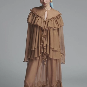 Detail of brown ruffled chiffon blouse with elegant layered pleats and neckline slit