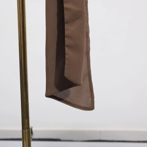 Detail view of lightweight brown chiffon fabric showing texture and hem quality