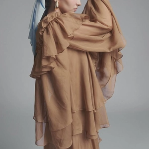 Detailed view of layered ruffles and sheer mesh texture on the camel brown long sleeve blouse