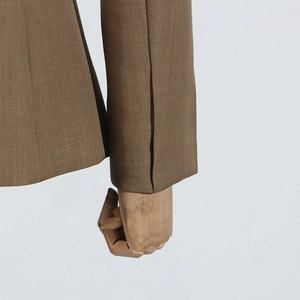 Detailed close-up of brown casual blazer cuff showing stitching and woven fabric texture