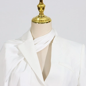 Detail view of white asymmetrical scarf-neck design with pleated draped collar