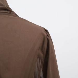 Detail of the dark brown sheer long-sleeve top with high neck and shoulder stitching