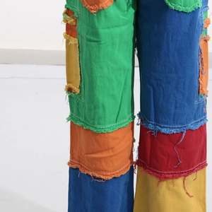 Detail view of colorful patchwork denim with distressed frayed edges and street style texture