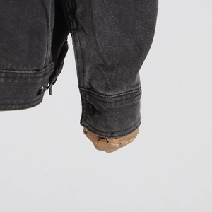 Détail de la manchette d'une veste en jean gris anthracite avec bouton et coutures précises