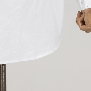 Close-up of double-needle hem stitching on white heavy-duty rhinestone shirt for women