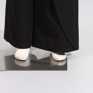Detail view of black high waist wide leg pants with elegant drape and clean hem finishing