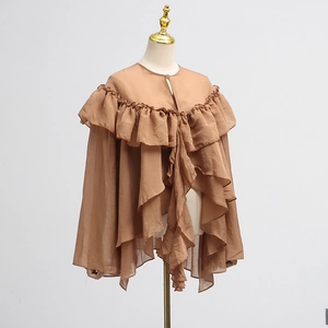 Detail of a brown chiffon top featuring elegant layered ruffles and sheer mesh panels
