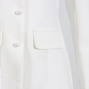 Detailed macro view of white blazer with elegant pearl buttons and flap pocket