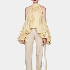 Detailed front view of light yellow halter neck pleated top with puff sleeves and trousers