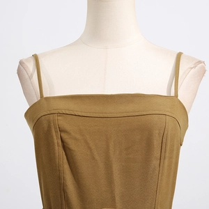 Detail of olive yellow jumpsuit showing square neck and structured fishbone stitching