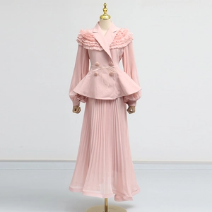 Detail of light pink two-piece set featuring ruffled blazer top and pleated maxi skirt