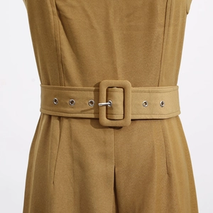 Detail of khaki jumpsuit featuring a wide belt with silver eyelets and a large buckle
