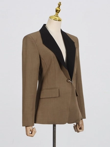 Elegant tan women's blazer with black lapel and metal button on a professional mannequin