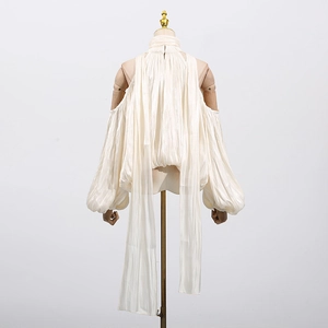 Detail of pearl white pleated halter top with elegant oversized lantern sleeves and ties