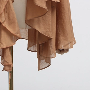 Close-up of brown chiffon blouse featuring layered ruffle edges and mesh stitching detail