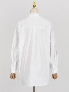 Relaxed white shirt with rhinestone embellishments on collar and cuffs, back view display
