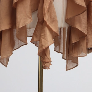 Detail of elegant ruffled hem on a brown chiffon blouse featuring delicate stitching
