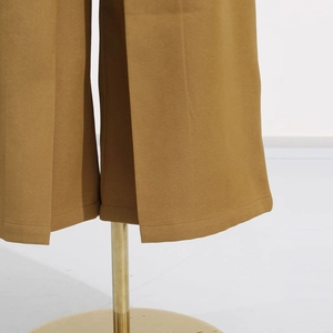 Detail of wide-leg jumpsuit hem featuring vertical pleats and precise stitching quality