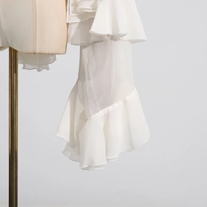 Detail of elegant white chiffon sleeves with layered ruffle design and flare cuffs