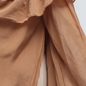 Close-up of ruffled mesh stitching and textured fabric on casual long sleeve shirt