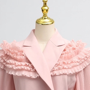 Detail of pink blazer with elegant ruffled trim on shoulder and notched lapel