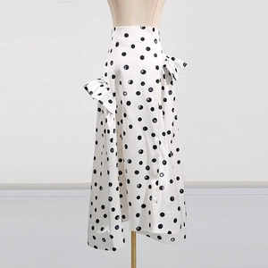 Détail de la jupe taille haute blanche à pois noirs avec des volants plissés