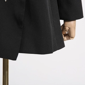 Close-up of a black slim-fit blazer with textured fabric on a professional mannequin