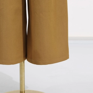 Detail of the hem on brown wide-leg jumpsuits with premium woven fabric stitching