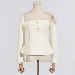 Detail of elegant cream top with asymmetrical mesh neckline and rhinestone buttons