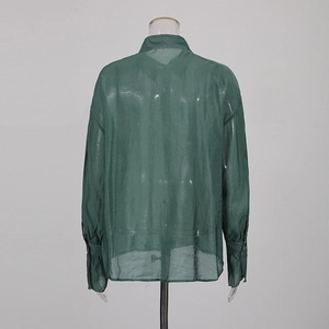 Detail view of the green sheer long sleeve blouse showing back tailoring and translucent fabric