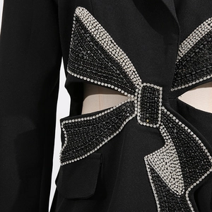 Exquisite detail of handcrafted rhinestone bow and cutout on black tailored blazer