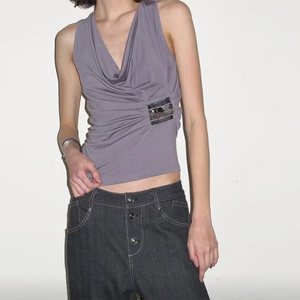 Detail view of purple sleeveless top featuring pleated V-neck and black sequin side accents