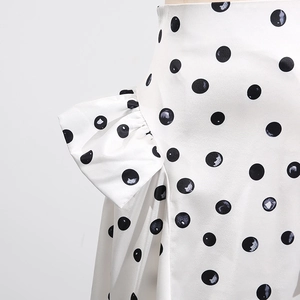 Détail de la jupe blanche à pois avec d'élégants volants plissés et texture lisse