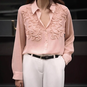 Close-up of elegant pink chiffon shirt showing ruffled details and pearl-like buttons