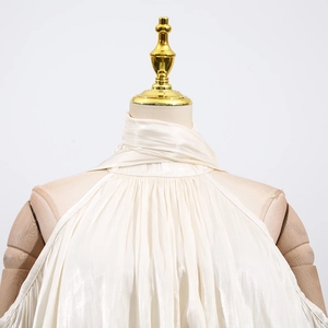 Detail of champagne satin halter top featuring pearlescent pleats on a mannequin