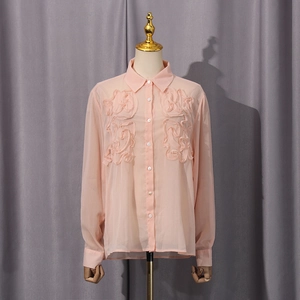 Detailed view of the 3D floral ruffles and light chiffon fabric on the pink long sleeve shirt
