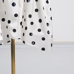 Détail du tissu léger à pois noirs avec des coutures de finition soignées
