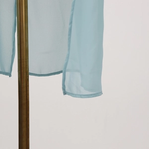 Close-up of light blue chiffon shirt hem with high-quality overlock stitching detail