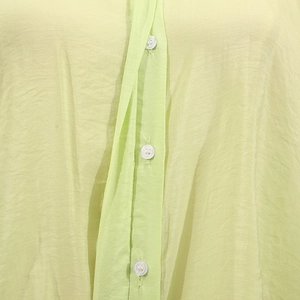 Close-up of light green blouse fabric with white buttons and fine horizontal texture