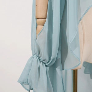 Detail of light blue chiffon shirt featuring split long sleeves and ruffled elastic cuffs