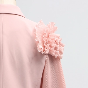Close-up of pleated ruffles and shoulder craftsmanship on a pink fashionable women jacket